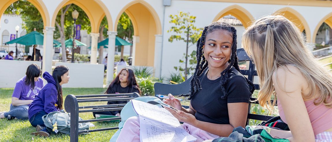 Two students talking and sitting on a bench at the Chalon Circle.