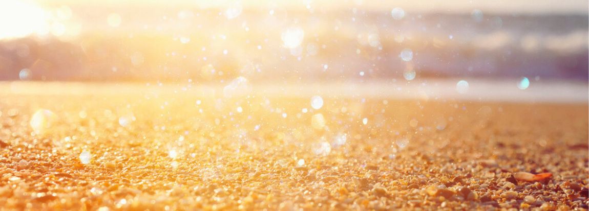 close up of sand and rocks glowing in the sun with sparkles in the air