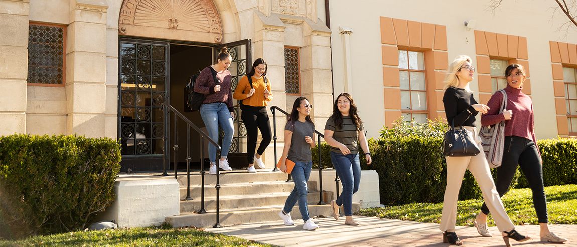 students walking out of administration building on campus