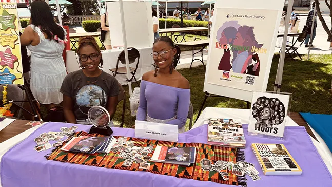 Members at the Black Student Union booth stand ready to answer questions about their group to prospective members who visit them during .Welcome Week