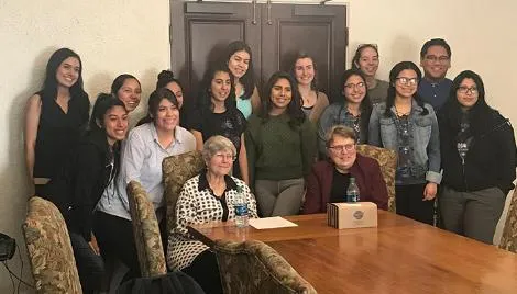 Students gather for a photo around Sister Annette Debs and Sister Theresa Kvale, following a Feet in The Street conversation.