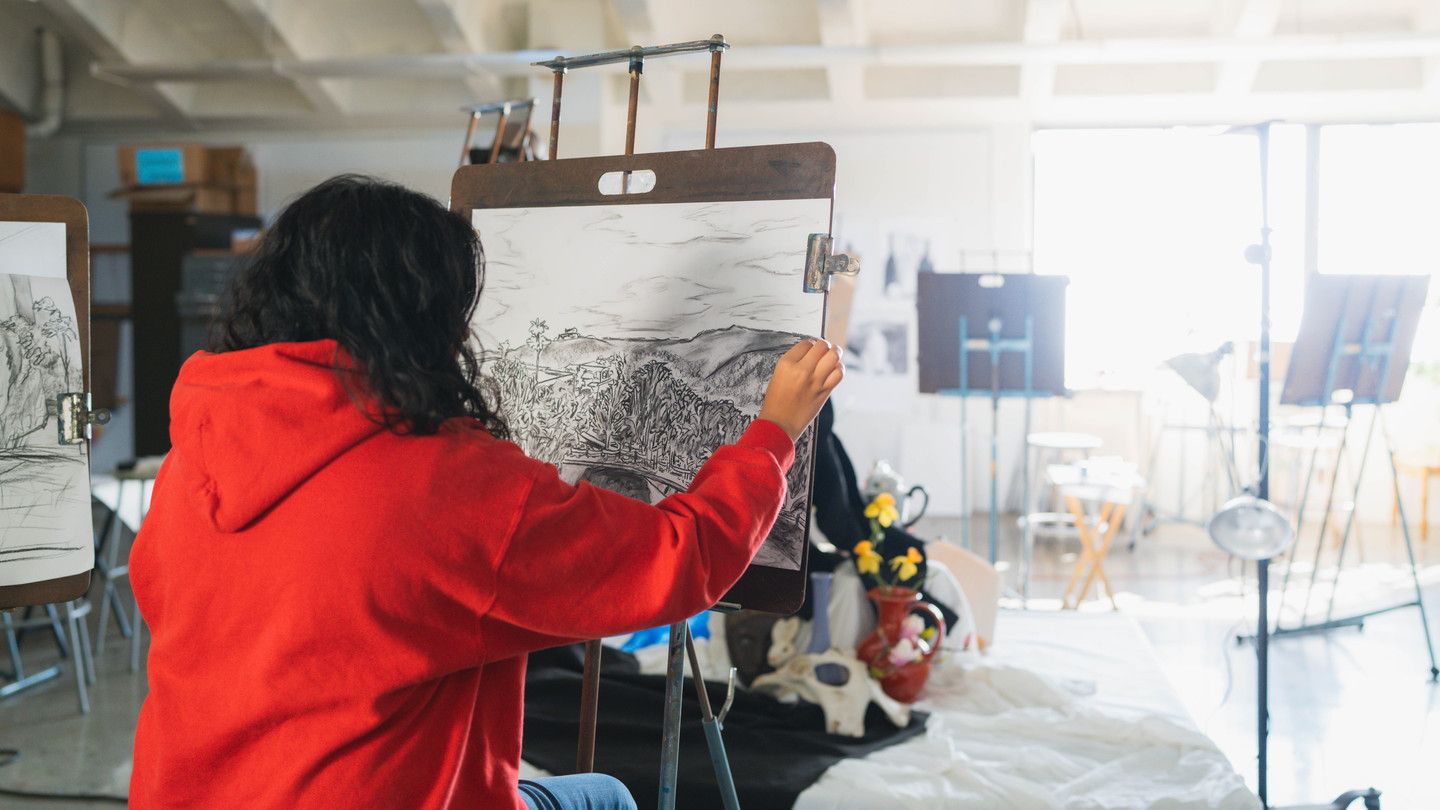 A student drawing with charcoal in a workshop