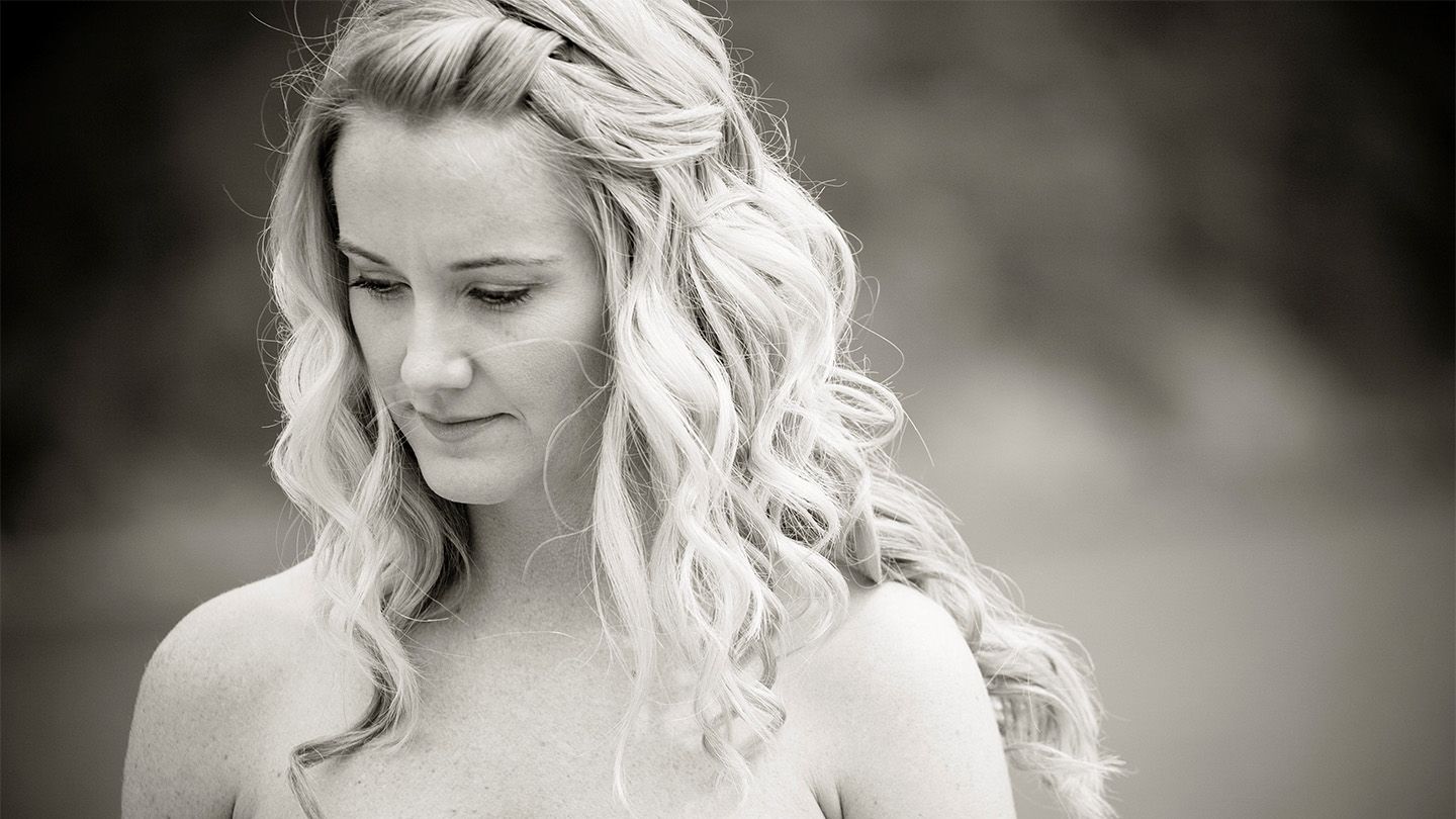 A black and white image of a woman looking downwards.