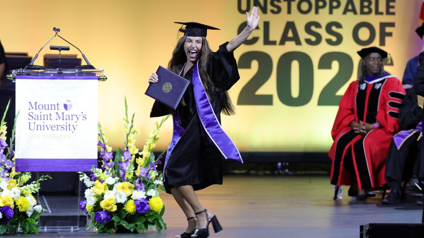 A Mount Saint Mary's University graduate celebrates with joy as she crosses the stage at the undergraduate commencement ceremony.