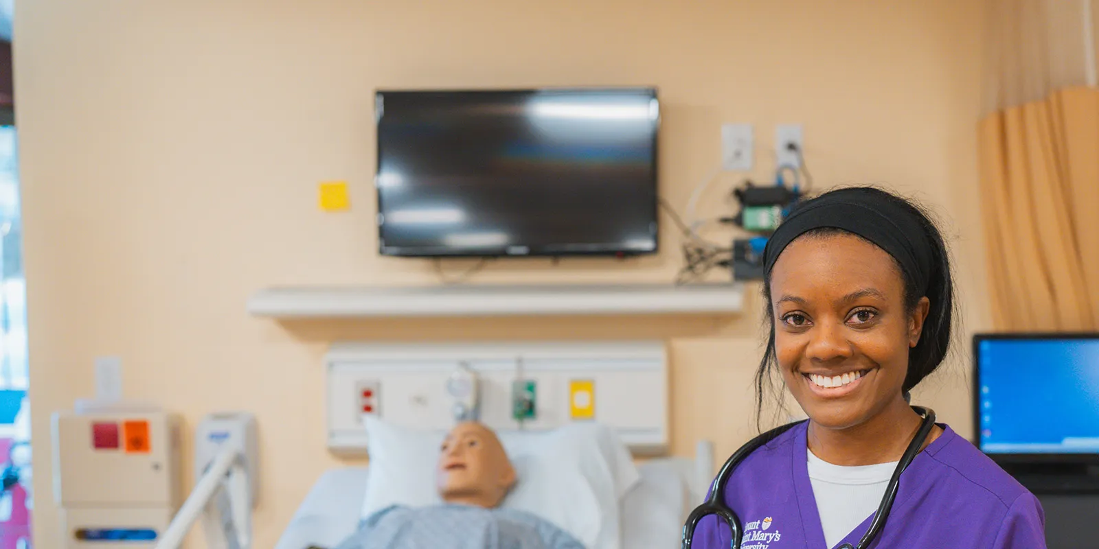 Two nursing students smiling in a hospital room