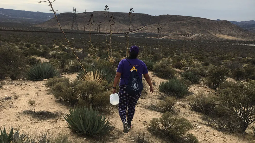Susan Cacique ‘19 carries a gallon of water in a well-traveled migration route near the Mexico-U.S. border during an alternative spring break service trip in March.
