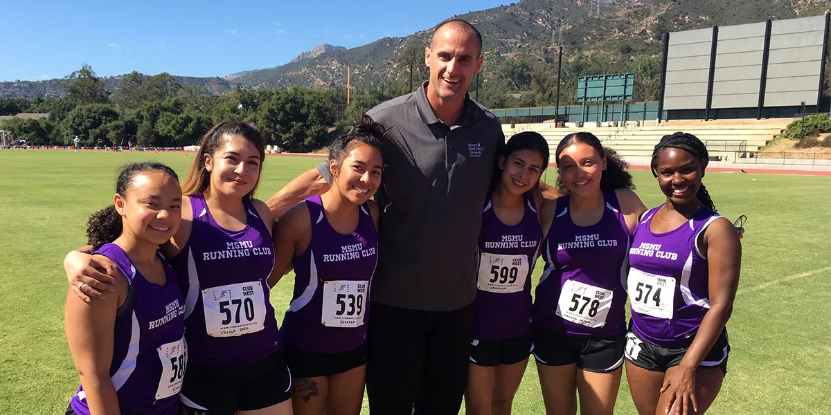 Coach Radenko Miskovic is surrounded by running club members at a recent open meet.