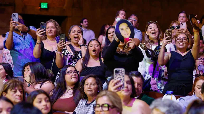 Family and friends cheer with pride as the graduates cross the stage.