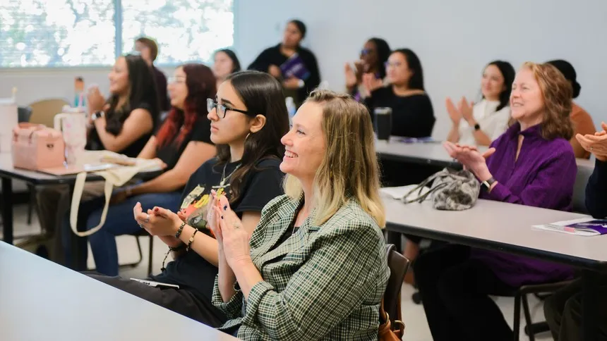Engaged and inspired, attendees applaud a student presentation at the symposium.