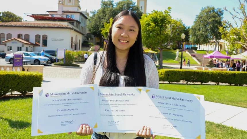 Mount student Taylor Nguyen shows her different recognitions during the Mary's Day ceremony.