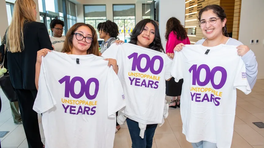 Students display commemorative “100 Unstoppable Years” T-shirts during the event.