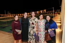 Alumnae posing for a photo at an evening event on the plaza.