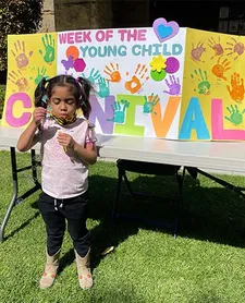 A child blowing bubbles in front of a decorated table