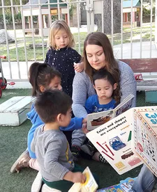 toddlers sitting on the ground and reading