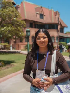 student smiling in front of the doheny mansion