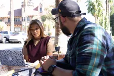 two students working together sitting outdoors on campus