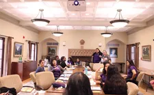 A group of students sitting around a long table during a meeting.