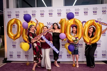 Alumnae posing with 100 balloons at gala