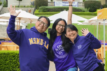 A student and her family posing at the parent orientation