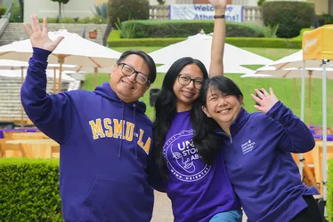 A student and her family hugging at the parent orientation