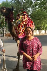 Portrait of a woman in front of a camel.