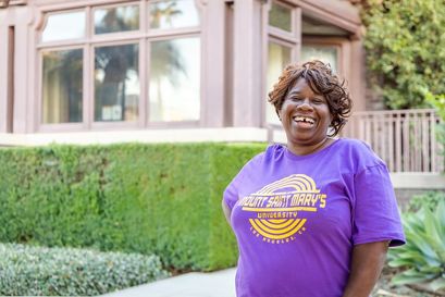 woman wearing a ÿ�մ������ purple shirt smiling standing outdoors on the doheny campus