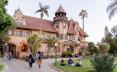 Doheny Mansion exterior shot with students walking in front lawn