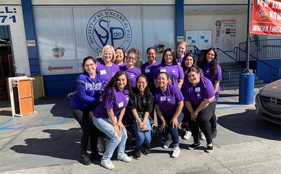 A group photo of students standing in front of the LA Society of St. Vincent de Paul.