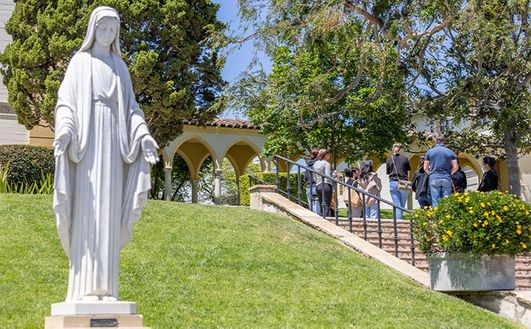 Statue of St. Mary with stairs and grass in the background