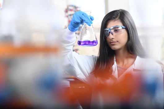 Student wearing lab coat working in a chemistry lab