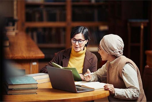 two women working together at a table