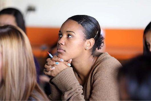 female student sitting in class listening