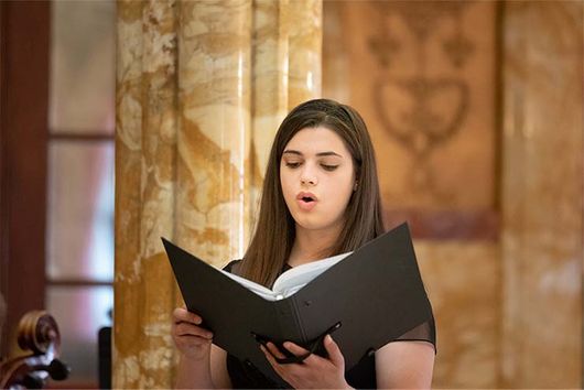 Woman singing in choir and holding a sheetbook