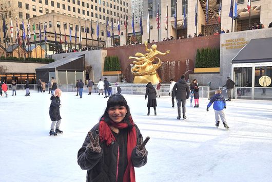 91ɬ�� Student smiling and giving the peace sign in front of the Rockefeller Center.