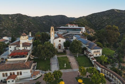 drone shot of chalon campus, showing buildings and mary chapel church against the mountains