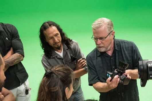 students working with professor with camera