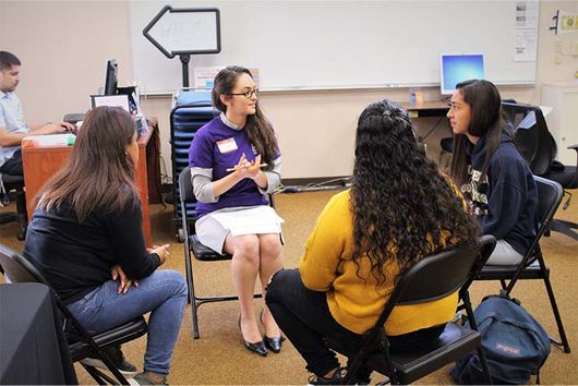 alumnae volunteer talking to students