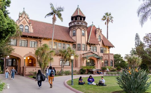 Doheny Mansion exterior shot with students walking in front lawn