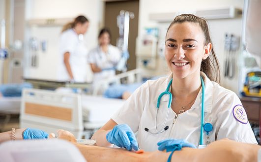 Nursing student practicing on arm
