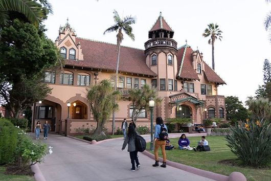 Doheny mansion with students walking in front yard
