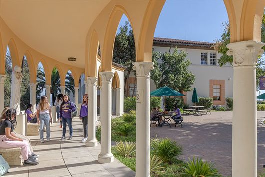 students walking exterior corridor