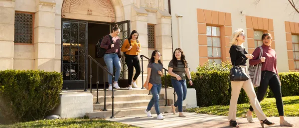 students walking out of administration building on campus