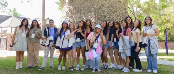 group of orientation leaders (students) standing on campus smiling