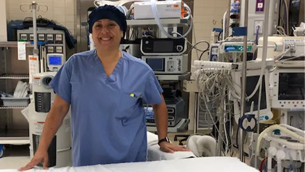 An image of a woman wearing scrubs in an operating room.