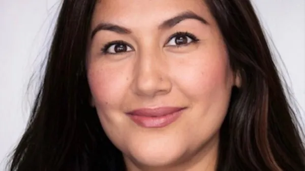 A portrait of a woman smiling at the camera.