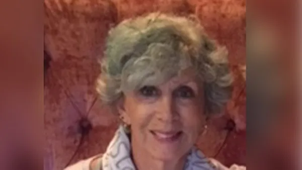 A portrait of a woman smiling at the camera.