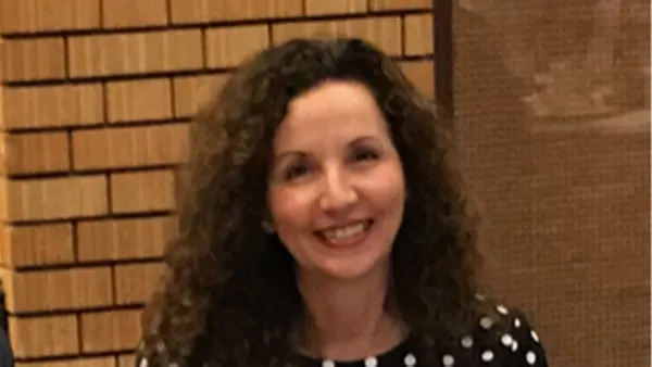 A portrait of a woman smiling at the camera.