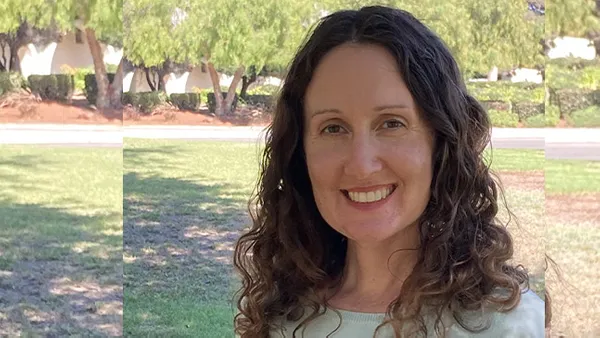 A portrait of a woman smiling at the camera.