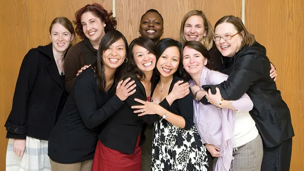 An image of women in a group photo smiling at the camera.