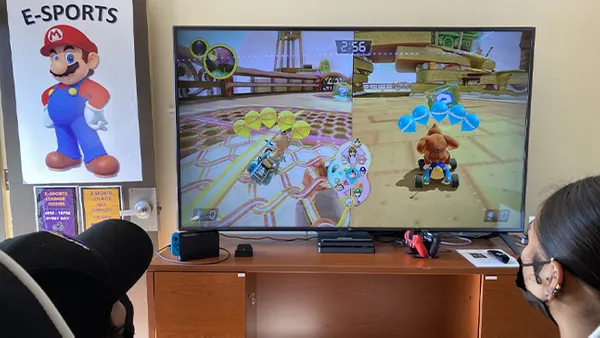 Students playing mario cart on a tv.